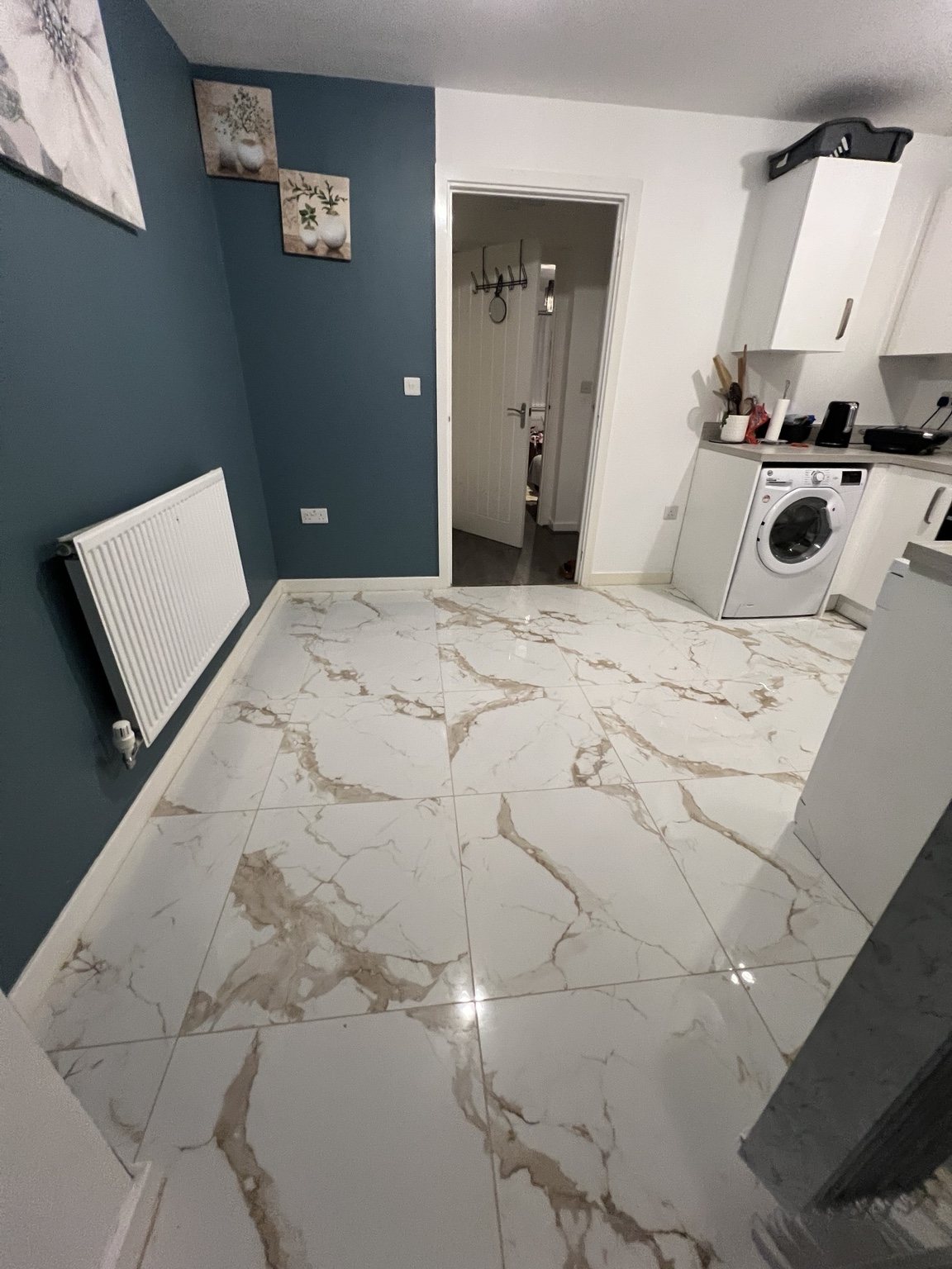 Kitchen and utility area with marble-effect flooring and a deep blue wall