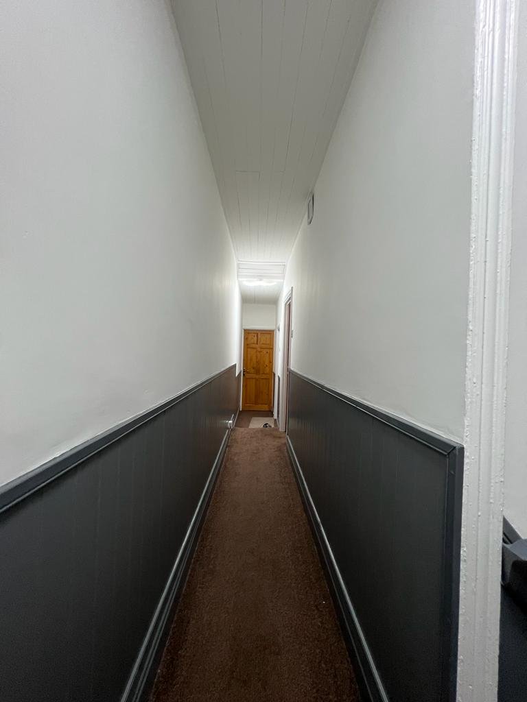 Hallway decorated with light upper walls, dark lower walls and dado rail