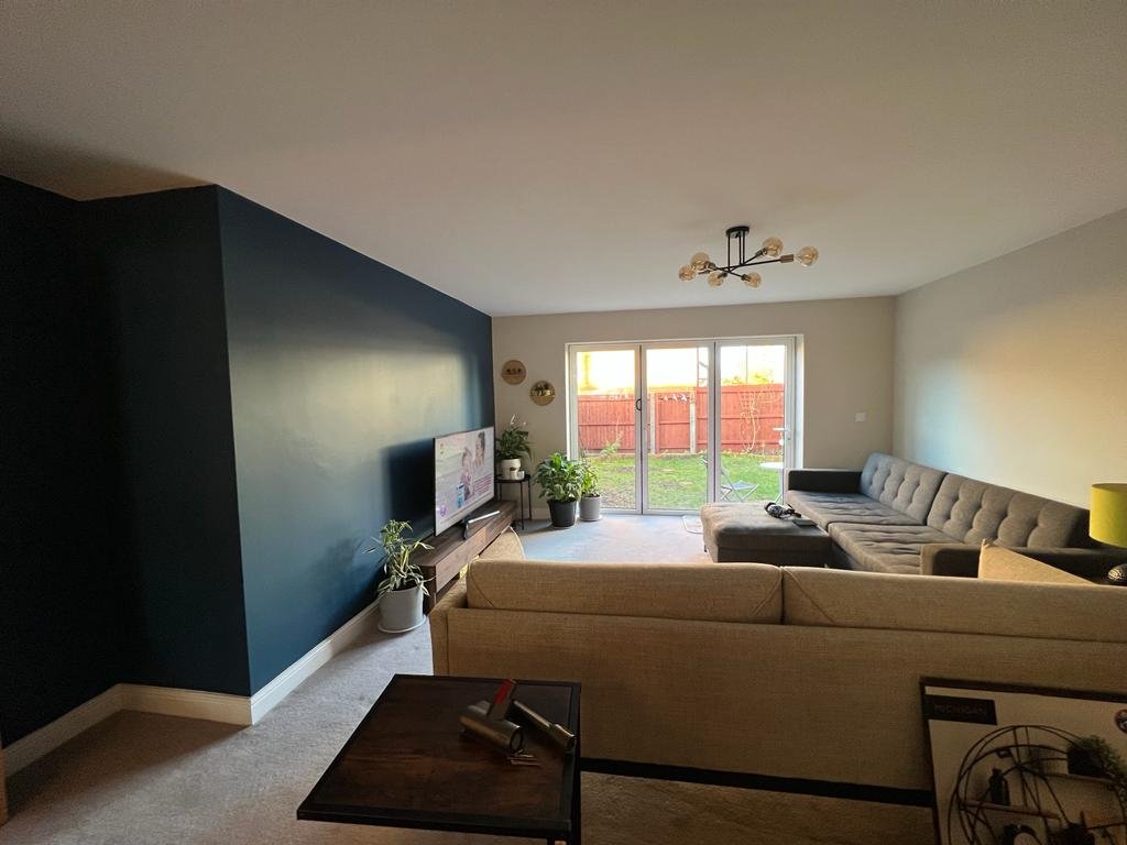 Living room with navy feature wall, pale surrounding walls and sofas